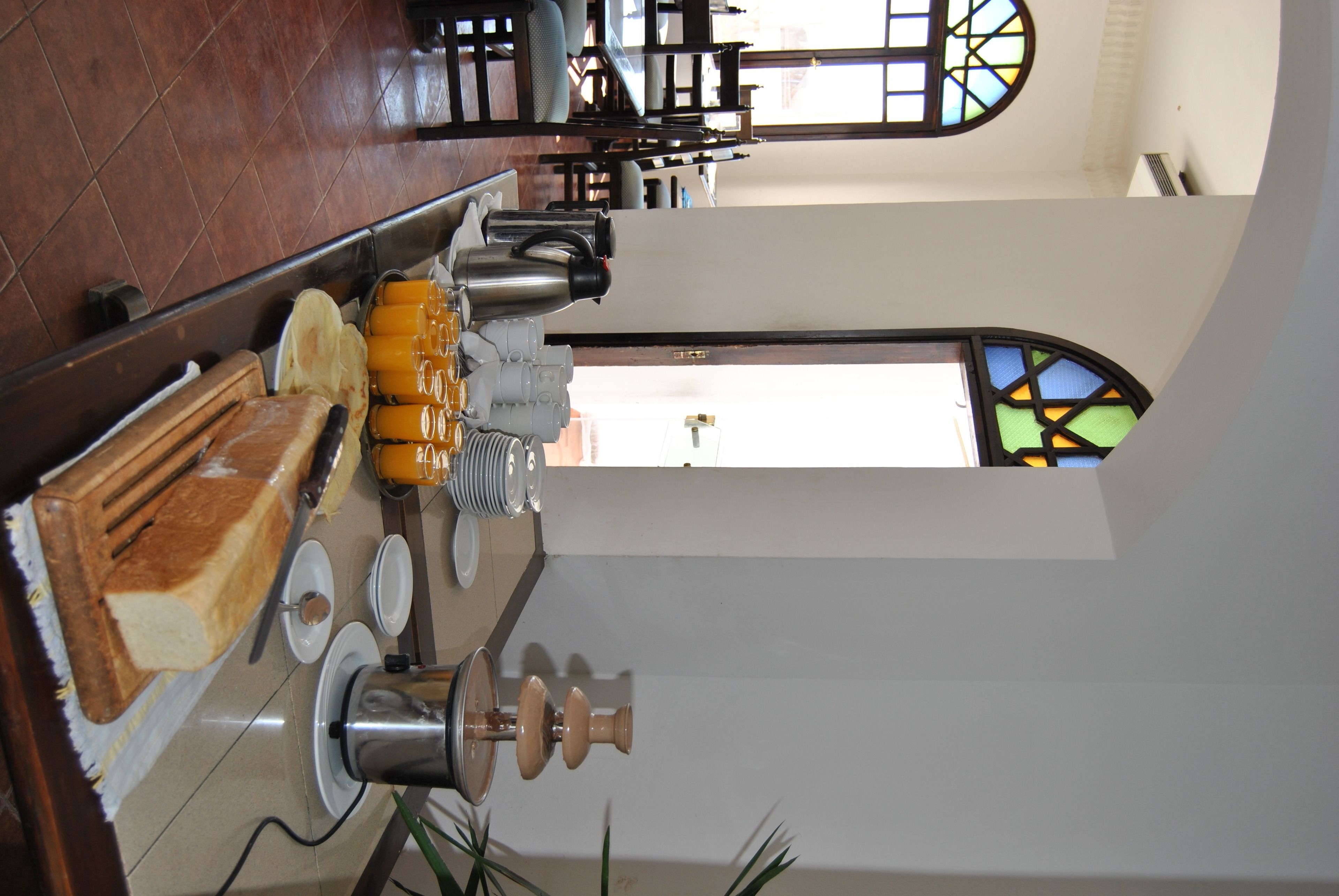 A breakfast setup with a toaster, coffee maker, and orange juice.