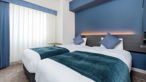 Une chambre d’hôtel avec deux lits, une table de chevet et une grande fenêtre avec des rideaux.