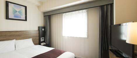 Una habitación de hotel con una cama grande, un televisor de pantalla plana, un escritorio con lámpara, un teléfono y una ventana con cortinas.