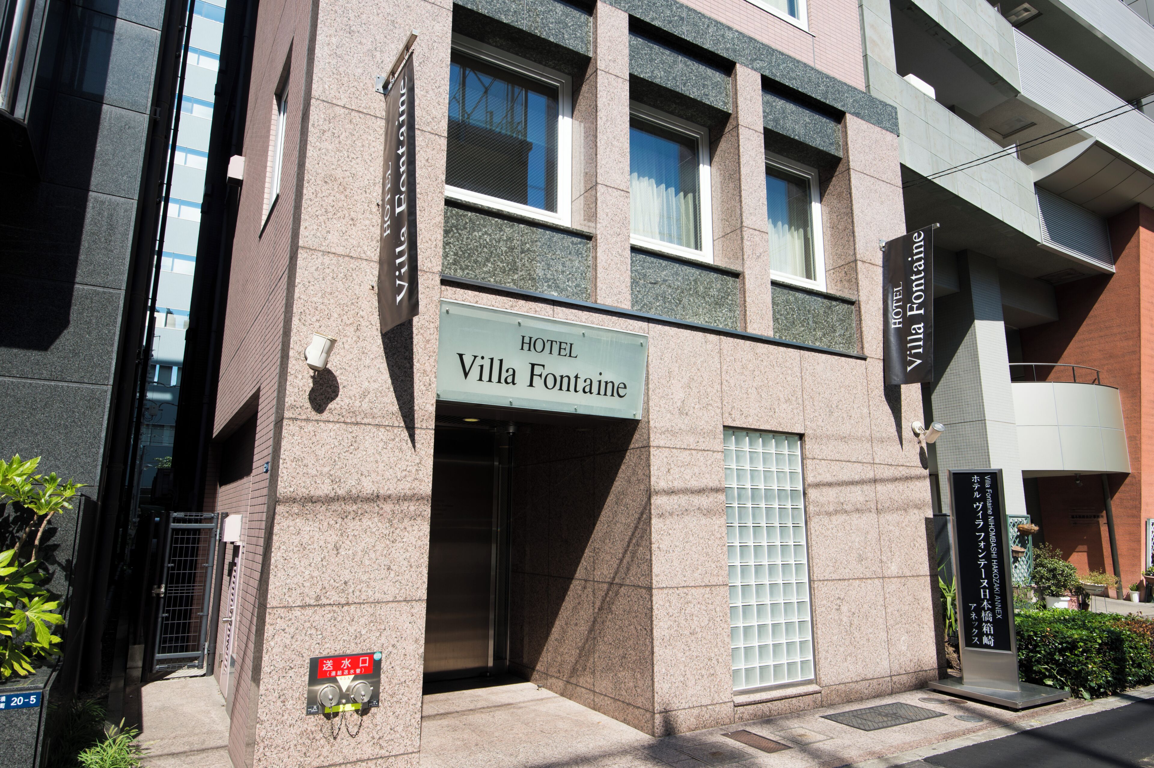 A hotel entrance with a sign reading 'Hotel Villa Fontaine.'