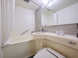 Ein Badezimmer mit Badewanne, Waschbecken, Spiegel und Toilette.