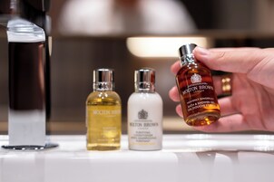 Three bottles of Molton Brown products on a shelf.