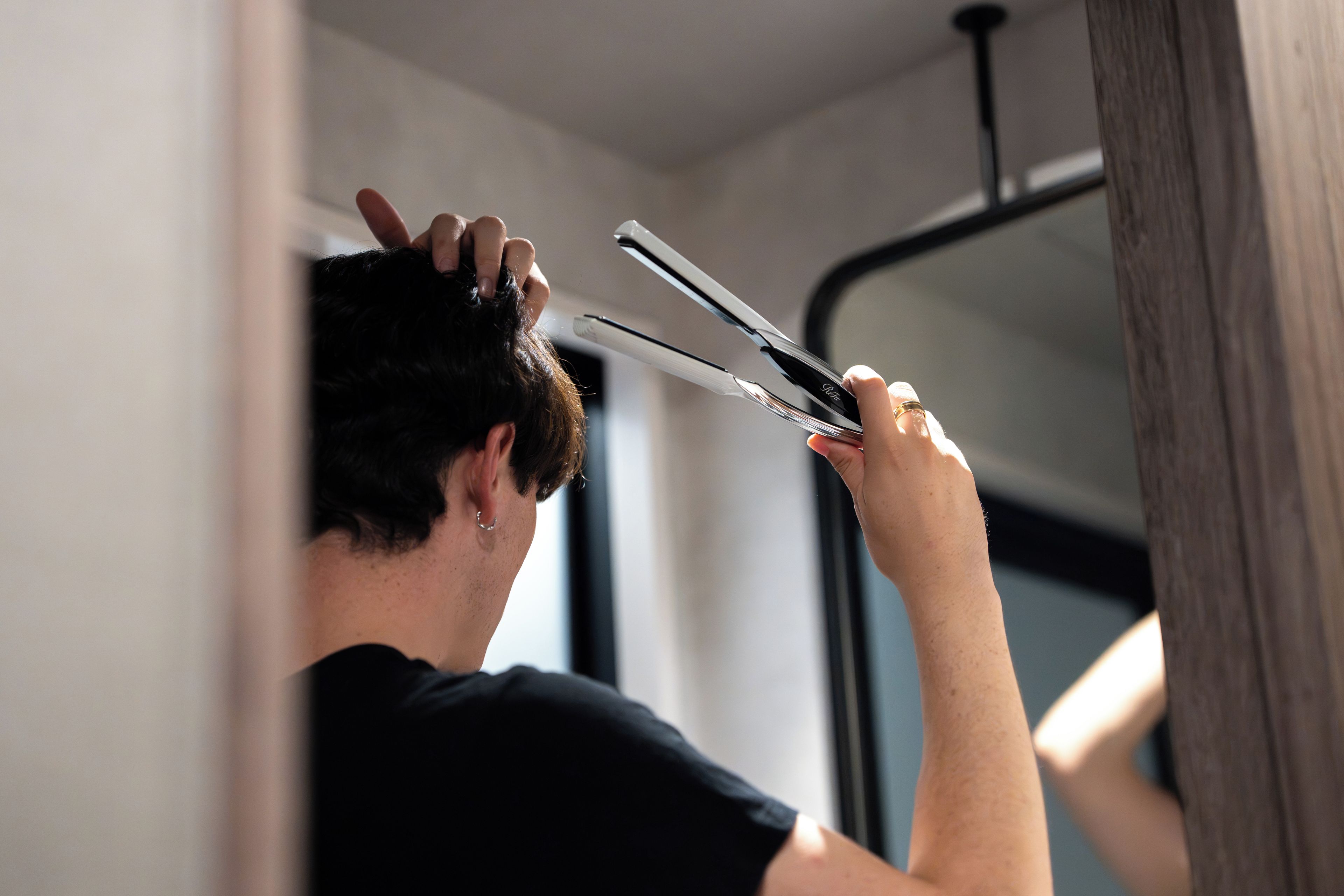 A person using a hair straightener.