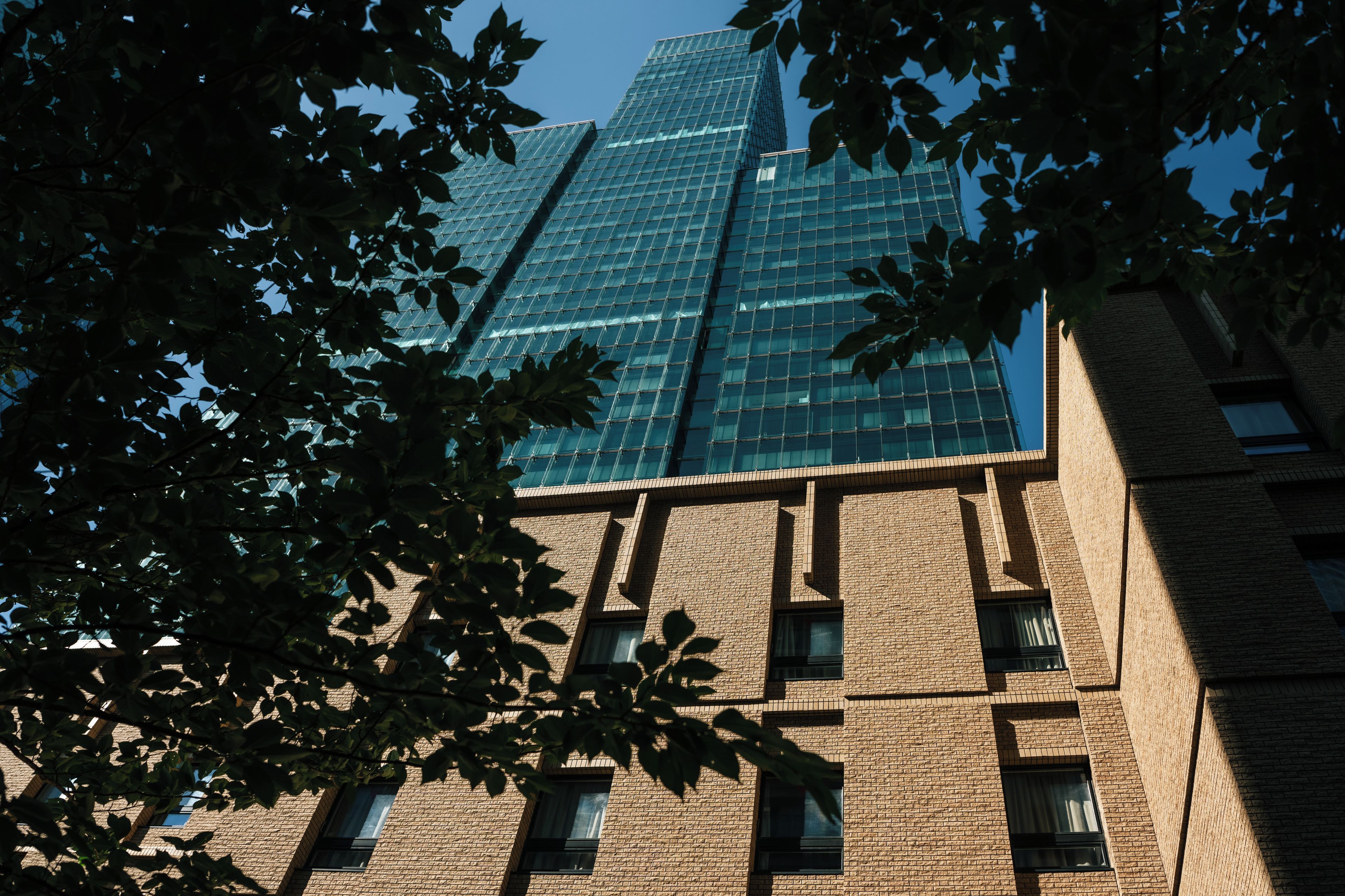A high-rise building with a glass facade and a brick lower section.