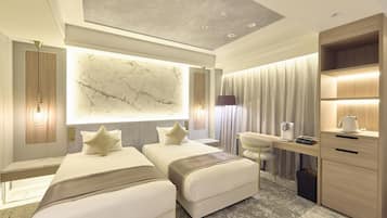 Una habitación de hotel moderna con dos camas, un escritorio, una silla y una gran pared de mármol.