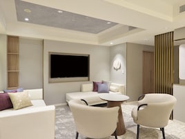 A modern living room with a flat-screen TV, two sofas, and a coffee table.