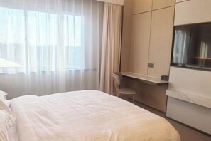 Ein Hotelzimmer mit einem Bett, einem Schreibtisch und einem Stuhl.