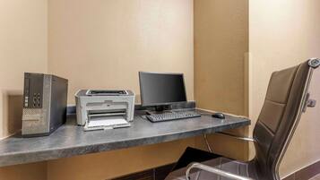A desk with a desktop computer, a printer, and a keyboard.