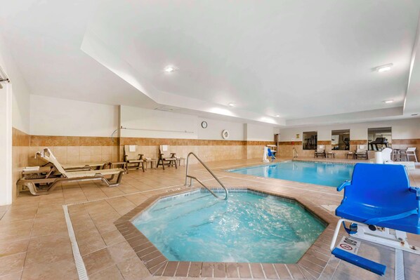 Indendørs swimmingpool med liggestole og et jacuzzi-område.