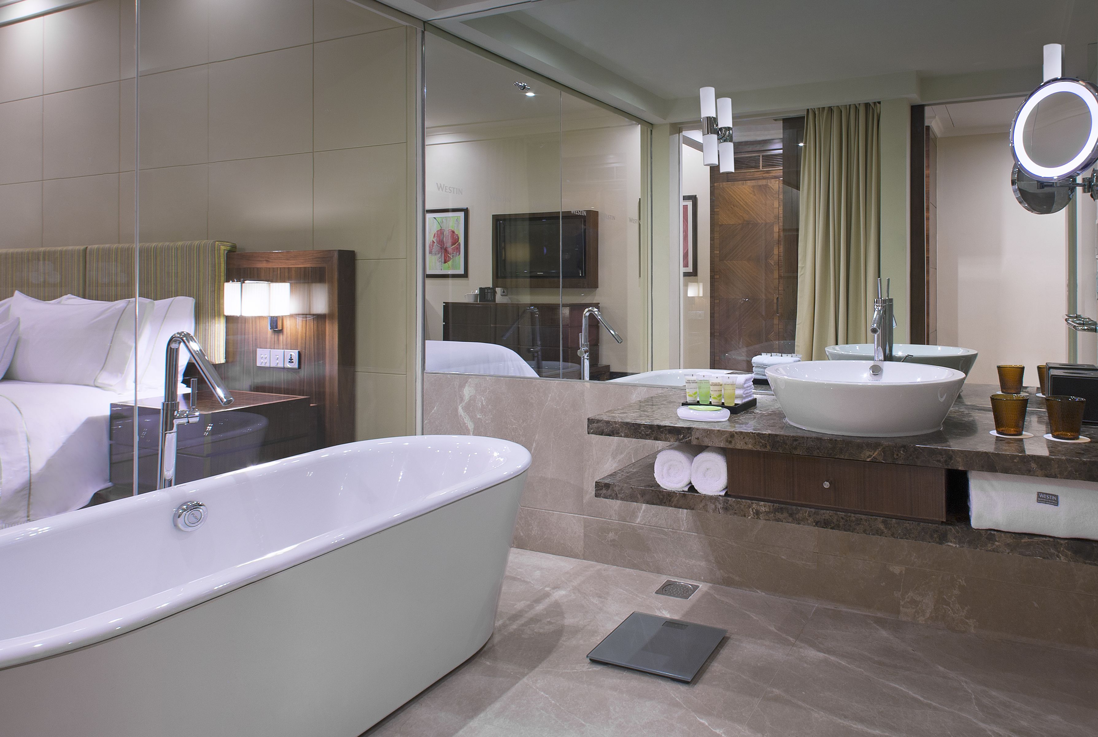 A modern bathroom with a large bathtub, a vanity with a sink, and a mirror.