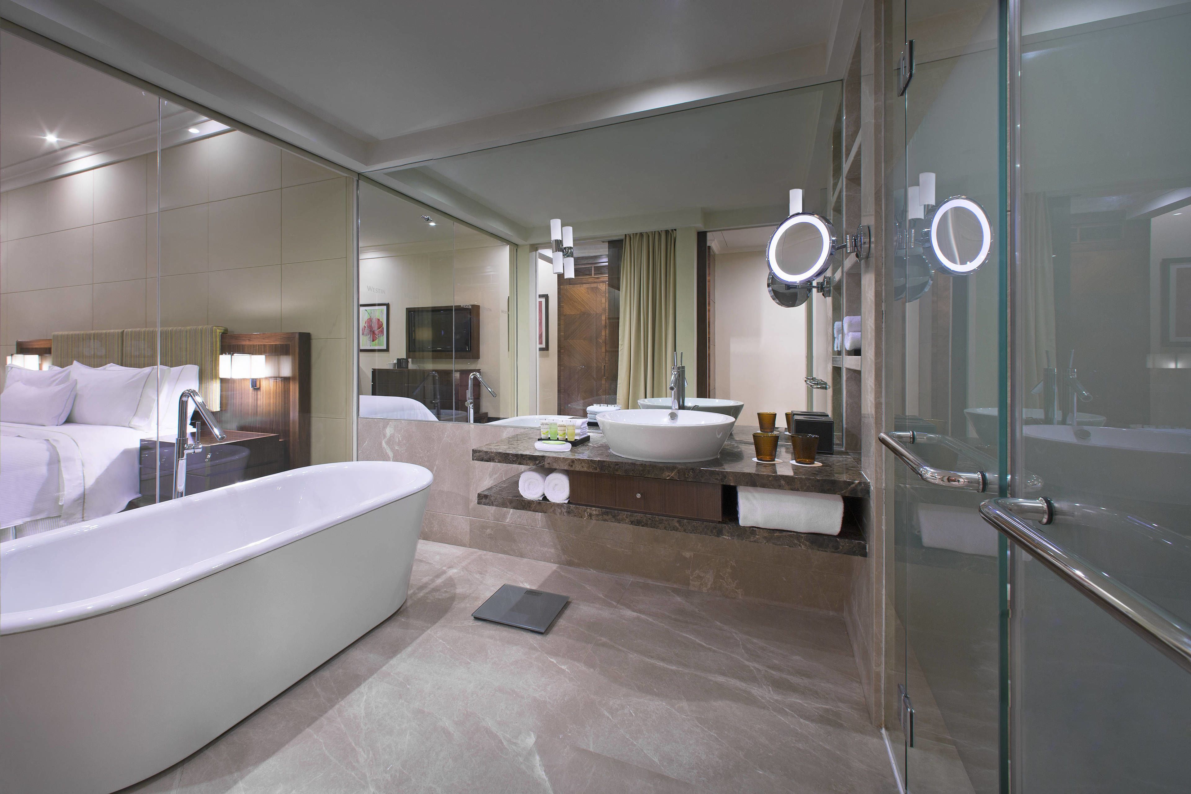 A modern bathroom with a large bathtub, a vanity with a large sink, and a glass shower enclosure.