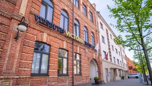 Un edificio histórico de ladrillo con un letrero que dice 'VICTORIA HOTEL'.