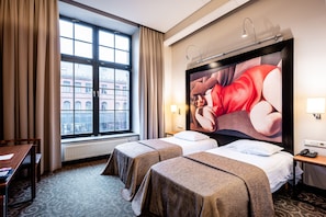 A hotel room with two beds, a large window with curtains, a desk, and a painting on the wall. - Victoria hotel Kaunas (Kaunas)