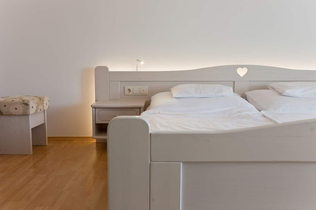 Un dormitorio con cama, mesitas de noche y velador.
