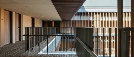 Un interior moderno con un entresuelo, una escalera y vistas al exterior.