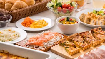 A variety of food items including salmon, quiche, and rice dishes, arranged on a table.
