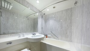 A modern bathroom with a white sink, mirror, and bathtub.