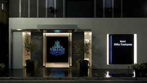 A modern hotel entrance with a digital chandelier display and a sign reading "Hotel Villa Fontaine".