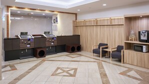 A modern reception area with a reception desk, computers, and a coffee machine. - Hotel Villa Fontaine Tokyo - Jimbocho (Tokyo)