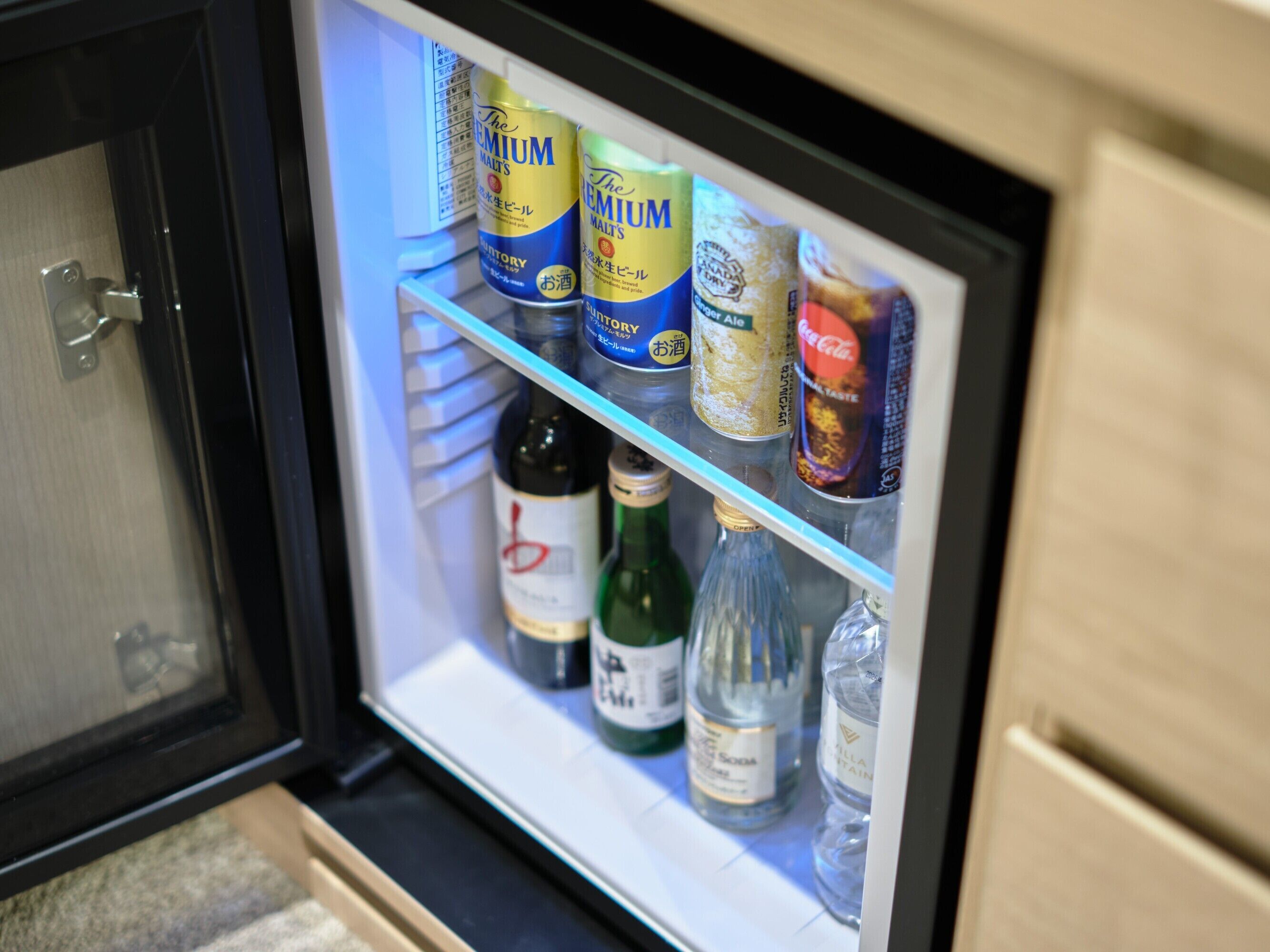 Egy minibar, amelyben különféle italok találhatók, beleértve a bort, a sört és a szénsavas üdítőket.