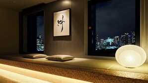 A modern room with a cityscape view, a framed artwork, and a textured light fixture. - Hotel Villa Fontaine Grand Tokyo - Shiodome (Tokyo)