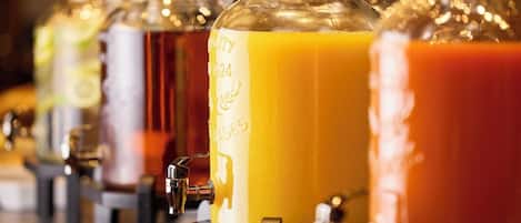 Una hilera de dispensadores de bebidas con botellas de vidrio transparente y grifos de metal.
