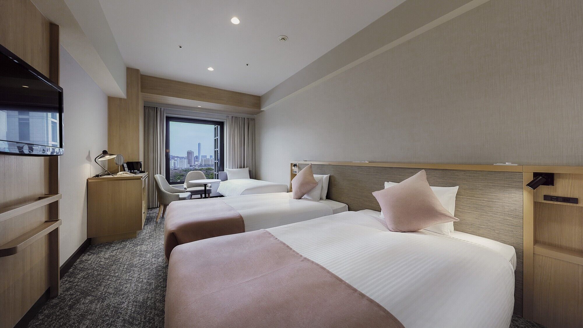 Une chambre d’hôtel avec deux lits, un bureau, une chaise et un téléviseur.