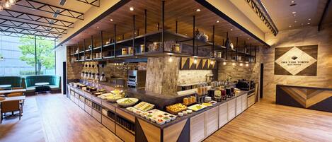 A modern restaurant with a central bar area, wooden flooring, and a view of the outdoors.