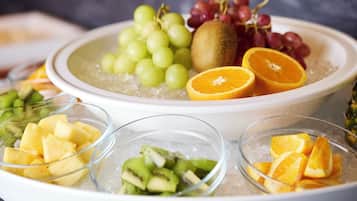 A bowl of ice with various fruits like grapes, kiwi, and orange slices.