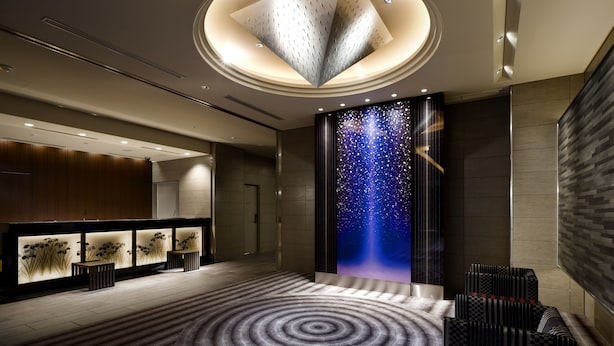 A modern lobby with a circular ceiling design, a starry wall mural, and a patterned carpet. - Village Kyoto close by Shijo Omiya station (Kyoto)