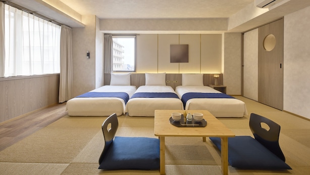 A hotel room with two beds, a small table with a tray, and a view of the city through the window. - Village Kyoto close by Shijo Omiya station (Kyoto)
