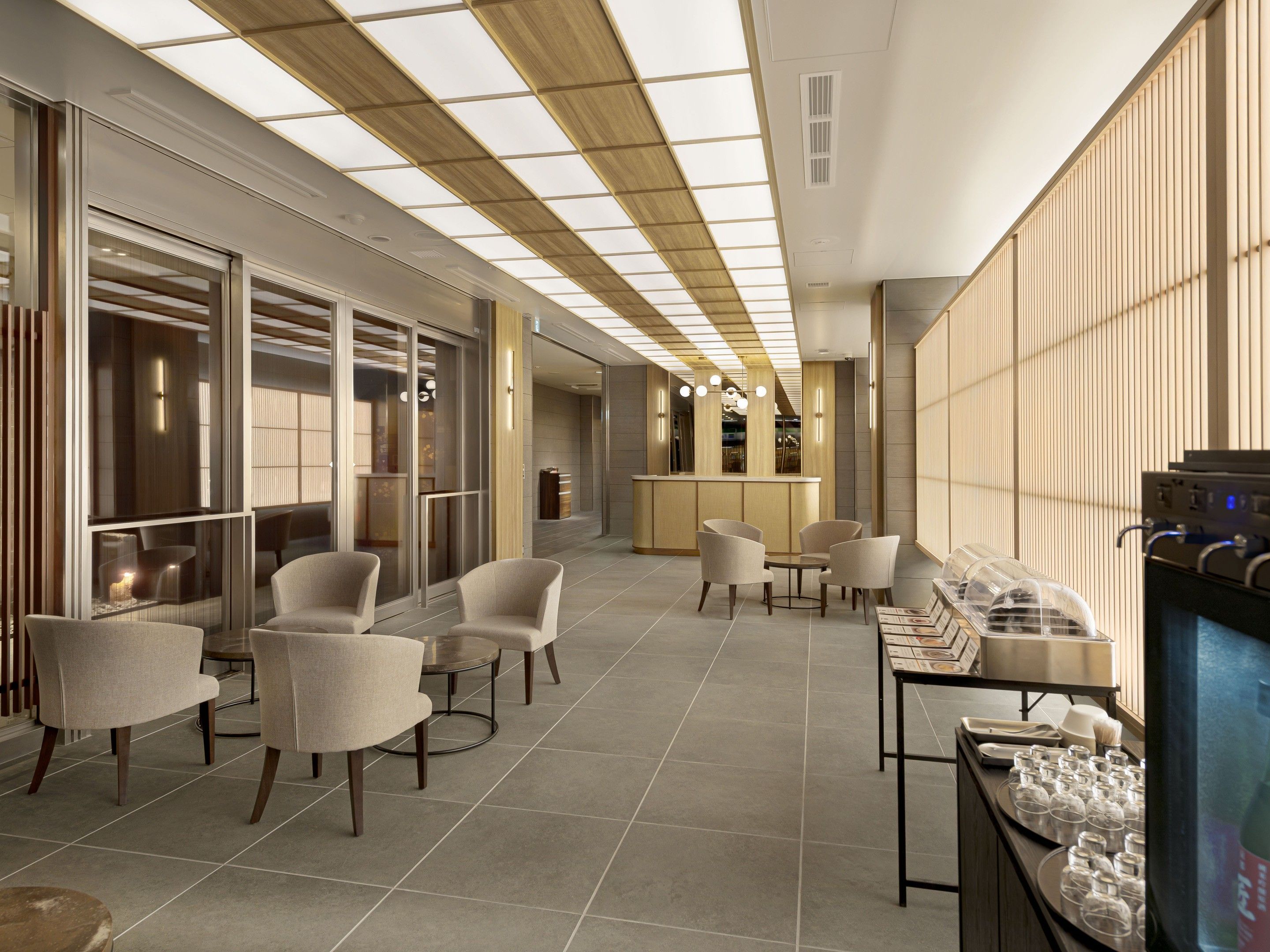Eine moderne Hotelhalle mit Sitzbereichen, einer Rezeption und einer Bar.
