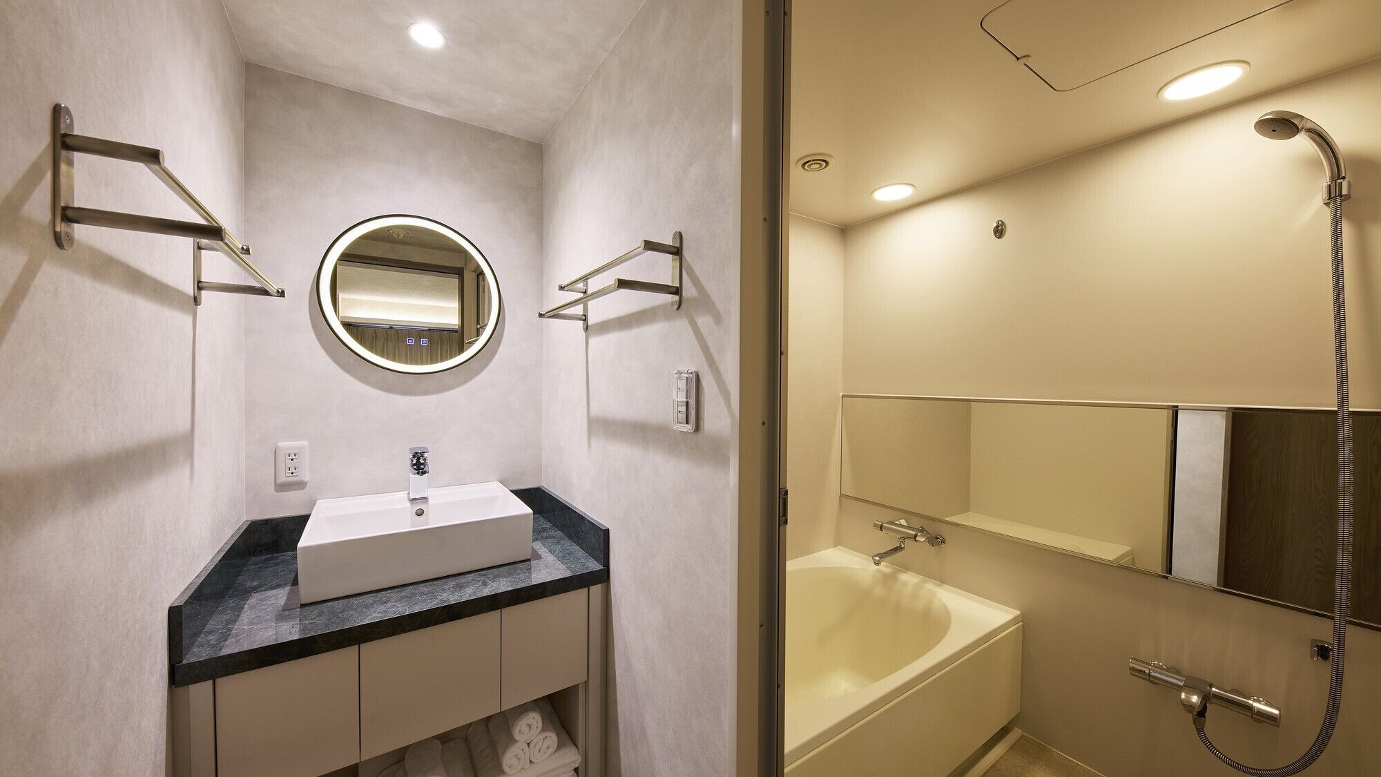 Un baño con lavabo, espejo, toallero y ducha.