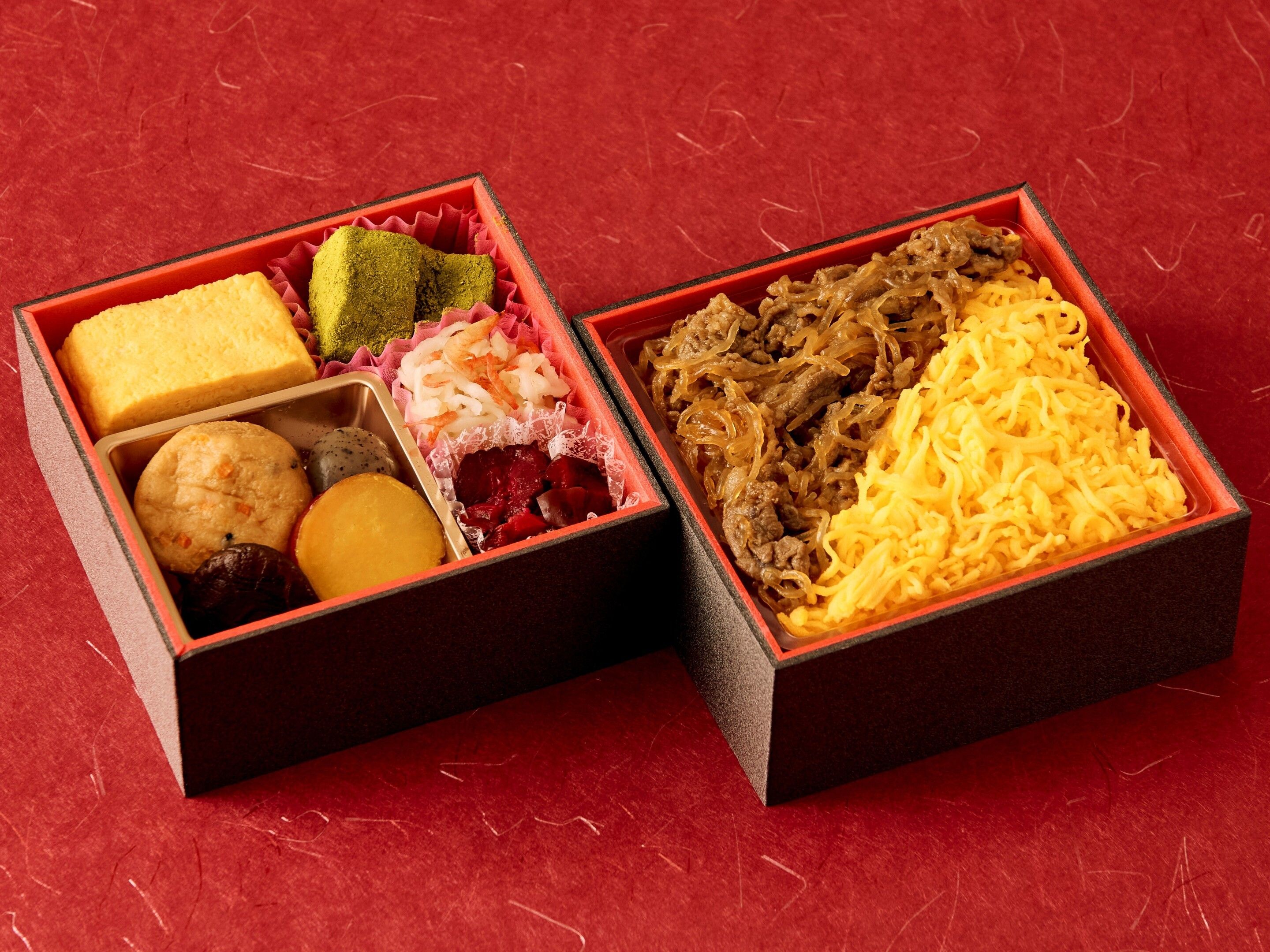 Two square boxes with compartments containing various food items.