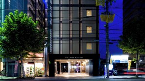 A modern hotel with a prominent sign, multiple floors, and a well-lit entrance. - Village Kyoto close by Shijo Omiya station (Kyoto)