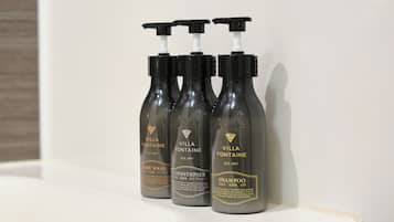 Three bottles of Villa Fontaine body wash, conditioner, and shampoo on a white surface.