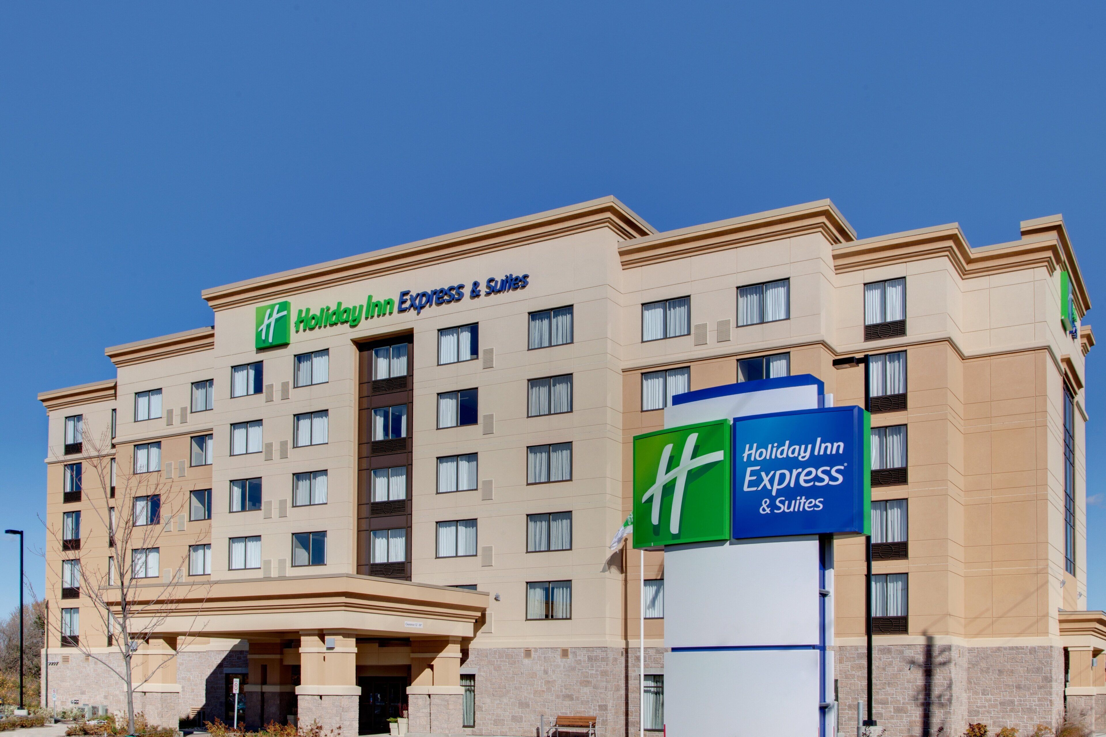 A Holiday Inn Express & Suites building with a clear blue sky.