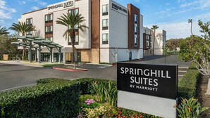 Ein modernes Hotel mit einem Schild, das "Springhill Suites by Marriott" zeigt, und einem überdachten Eingang.