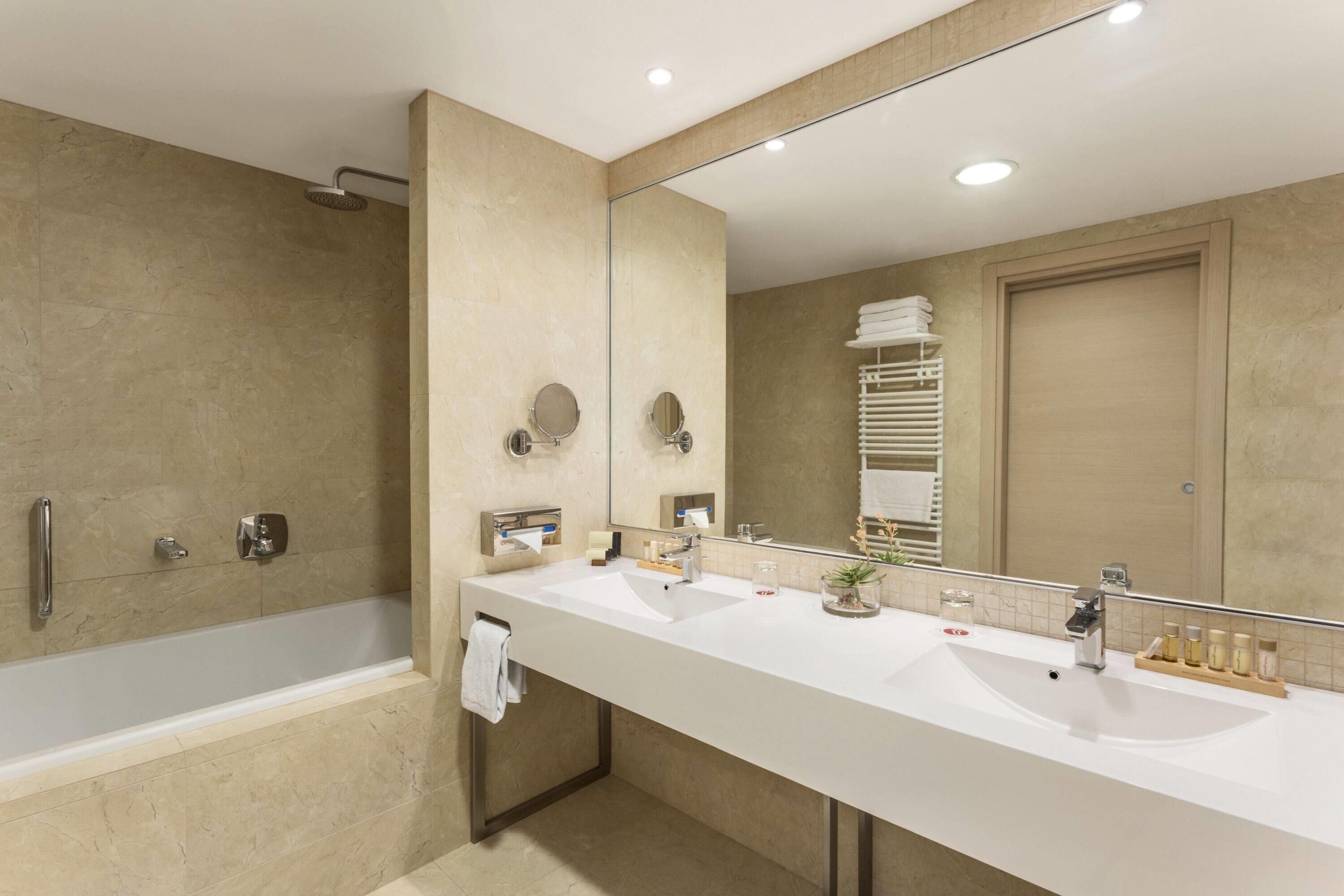 luxury suite, 1 king bed, non smoking | bathroom | eco-friendly toiletries, hair dryer, slippers, towels