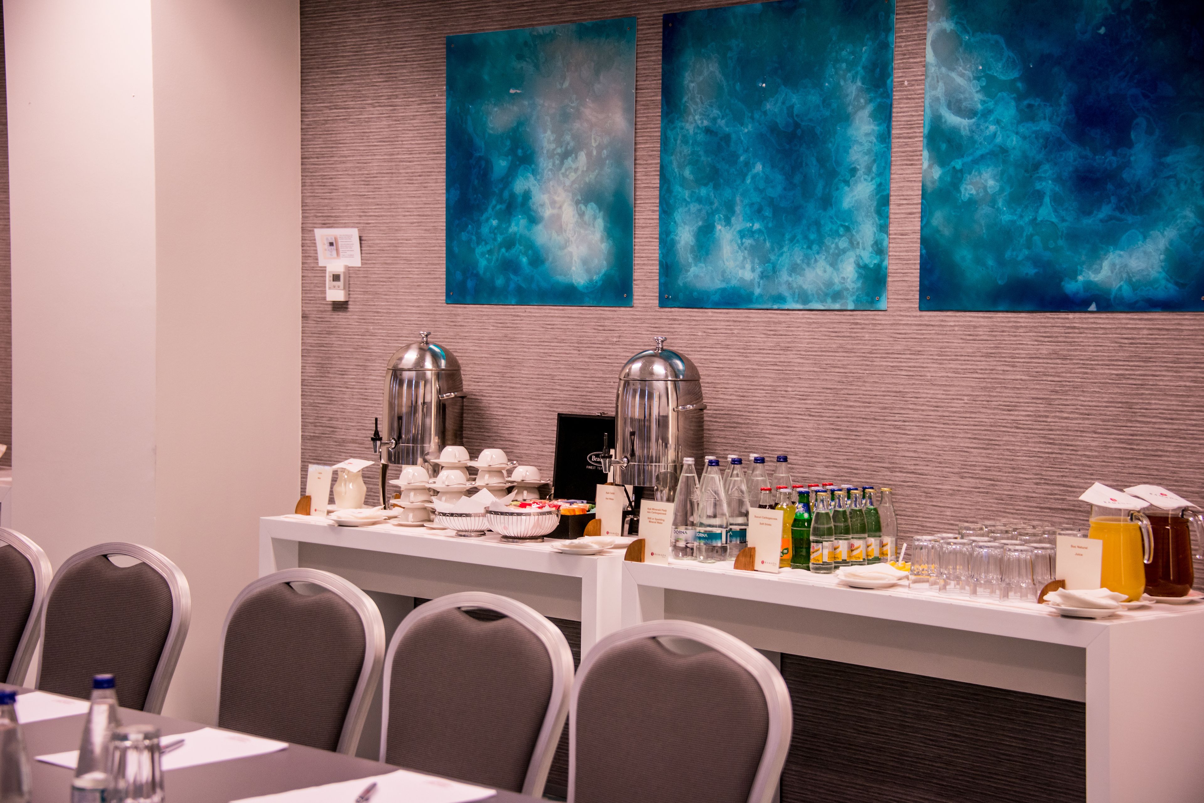 Een vergaderruimte met een buffetopstelling, inclusief eten, drinken en een koffiehoek.
