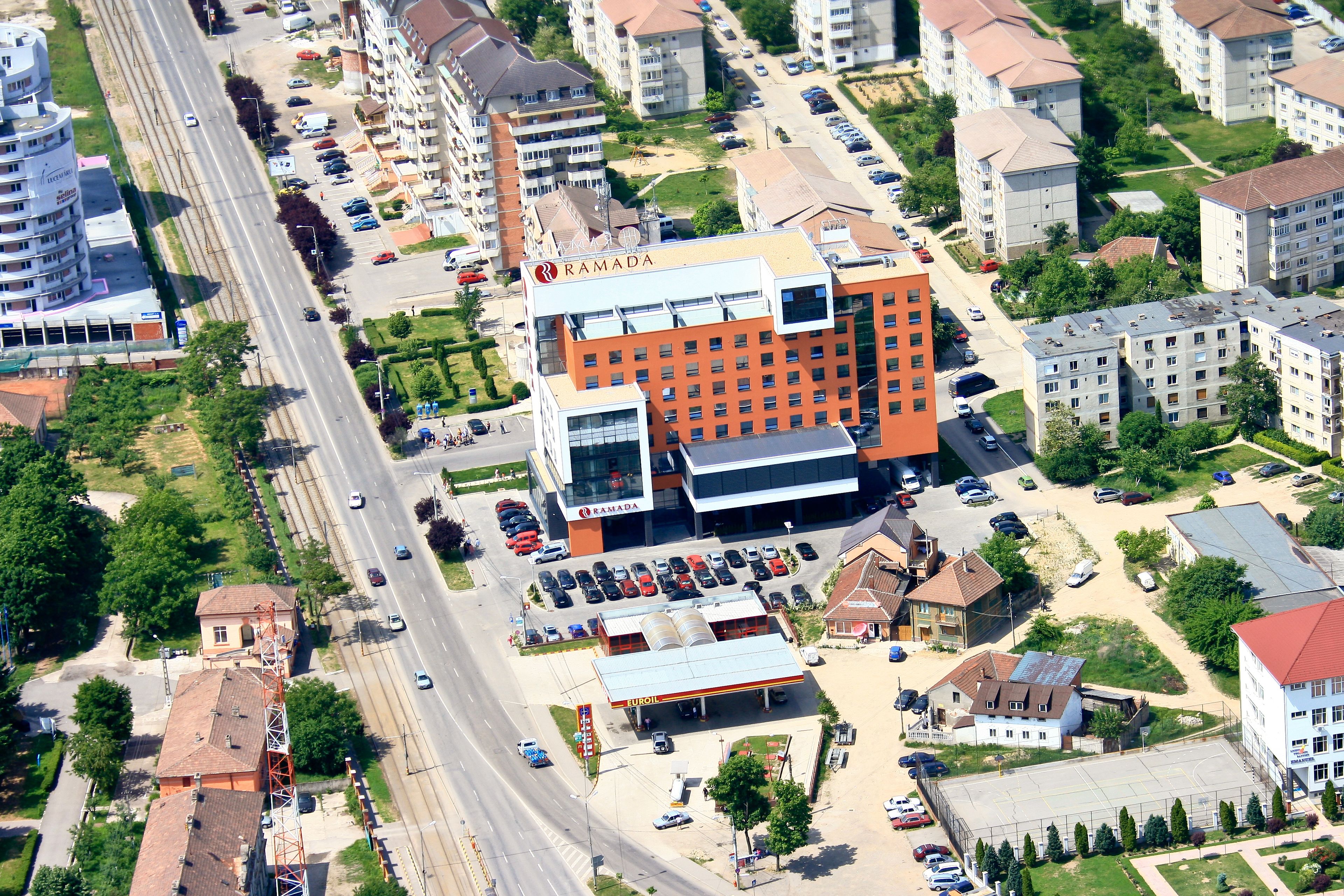 Een meerhoog gebouw met een opvallend oranje en wit bord, omringd door andere woongebouwen en een weg.