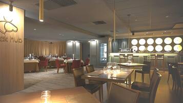 Un restaurante moderno con mesas, sillas, una zona de bar y un letrero que dice "Kik Hub".