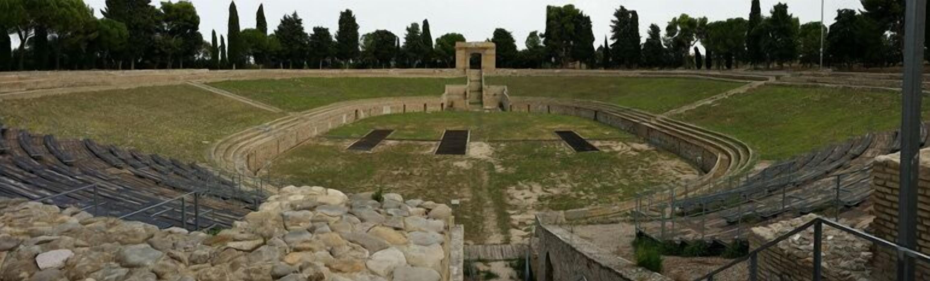 Un amphithéâtre antique doté de gradins en pierre et d’une scène centrale.