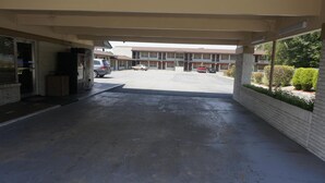A covered parking area with a building in the background. - Budget Inn Malvern (Malvern)