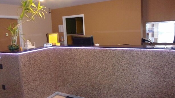 A reception desk with a granite countertop, a potted plant, and a small shrine. - Budget Inn Malvern (Malvern)