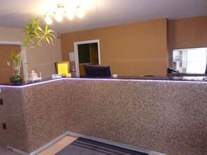 A reception desk with a granite countertop, a potted plant, and a small shrine. - Budget Inn Malvern (Malvern)