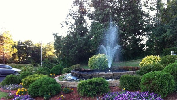 A garden with a fountain, various shrubs, and flower beds. - Liberty Inn (Old Saybrook)