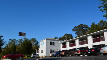 A motel with a sign reading "Liberty Inn" and a parking lot with several cars.
