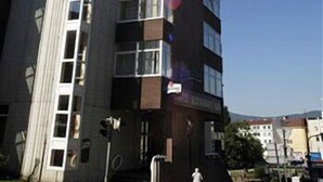 A multi-story building with a mix of window styles and a visible fire escape. - Hotel Liberec (Liberec)