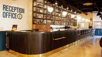 A reception area with a counter, shelves with various items, and a bar area with stools.